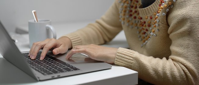 Kvinna som skriver på laptop